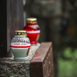 Na zdjęciu dwa znicze: biały i czerwony stojące przy pomniku Batalionu "Golski"