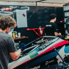 Na zdjęciu trzy osoby pracujące nad bolidem PD 2.5