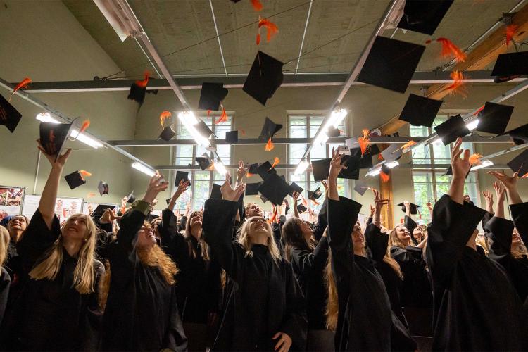 Absolwenci podrzucają birety
