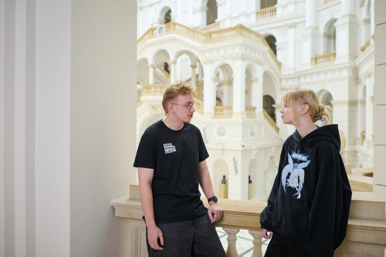 Na zdjęciu student i studentka stoją w Gmachu Głównym PW