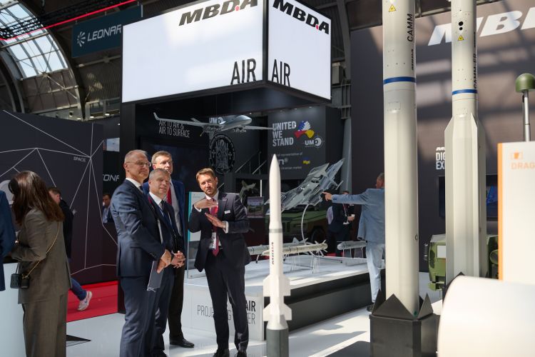 Na zdjęciu czterej rozmawiający mężczyźni - przedstawiciele Politechniki Warszawskiej i spółki MBDA Polska