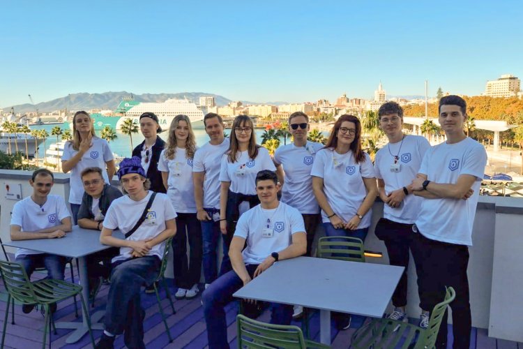 Na zdjęciu grupa ludzi. W tle widok na Malagę