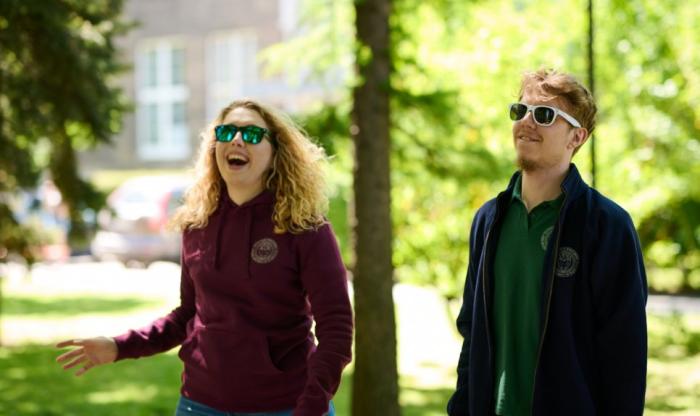 Zdjęcie uśmiechniętych studentów spacerujących po kampusie Politechniki Warszawskiej