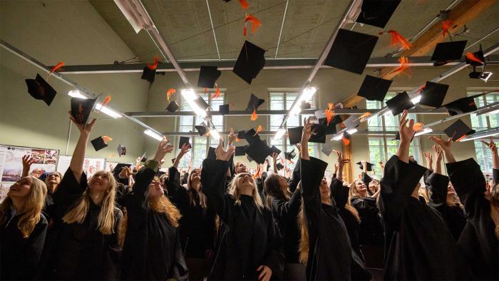 Absolwenci podrzucają birety