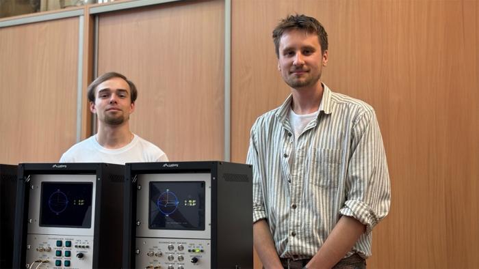 Dwaj studenci stoją obok stanowiska kubitowego