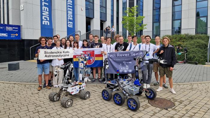 Na zdjęciu grupa studentów z dwoma łazikami marsjańskimi