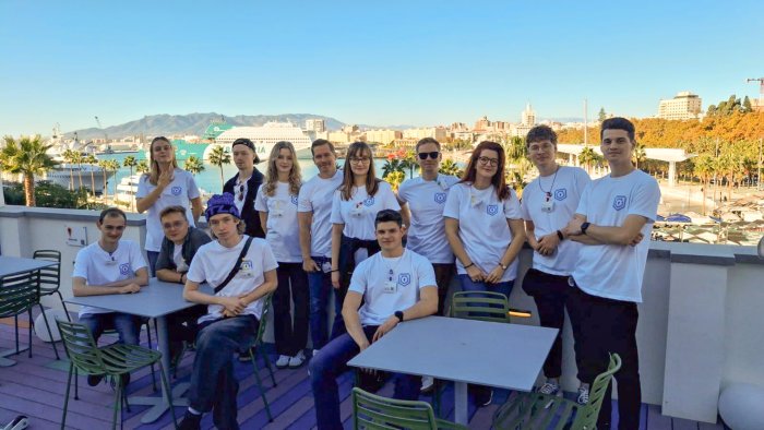 Na zdjęciu grupa ludzi. W tle widok na Malagę