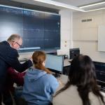 Zajęcia w laboratorium, prowadzący tłumaczy coś studentom