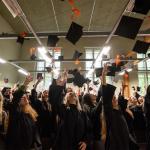 Absolwenci podrzucają birety