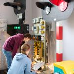 Na zdjęciu dwie osoby pochylone nad urządzeniami w laboratorium na Wydziale Transportu