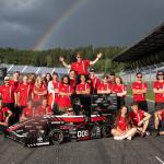 Na zdjęciu grupa studentów stojących na torze oraz bolid