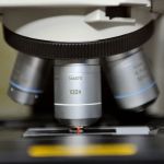 Zbliżenie na mikroskop, pod którym znajduje się preparat